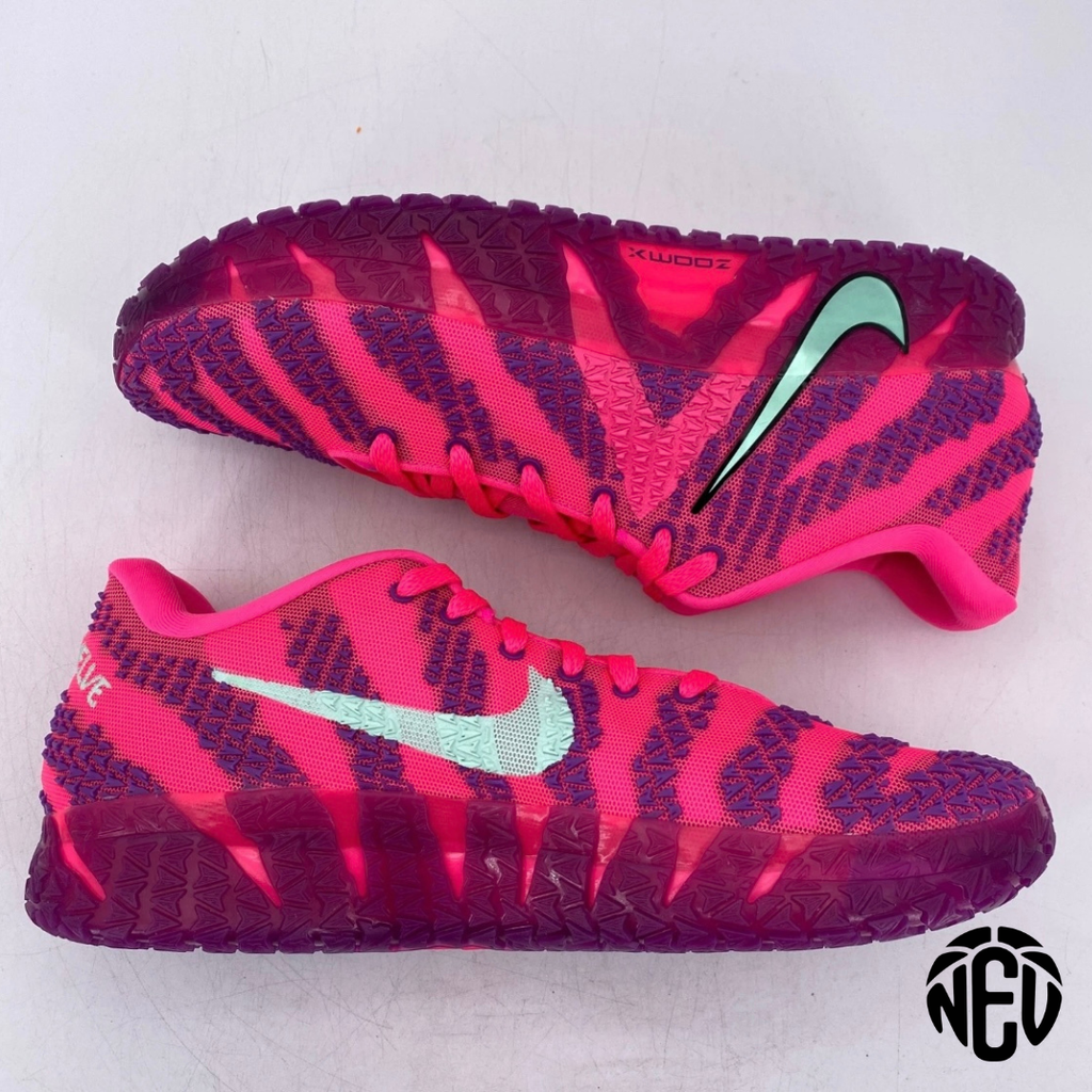 Pink and purple Nike shoes with a green swoosh logo on a white background
